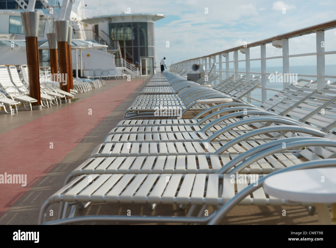 Leere Kreuzfahrt Schiff Liegestühle mit Matrose Reinigung, am frühen Morgen am Meer Stockfoto