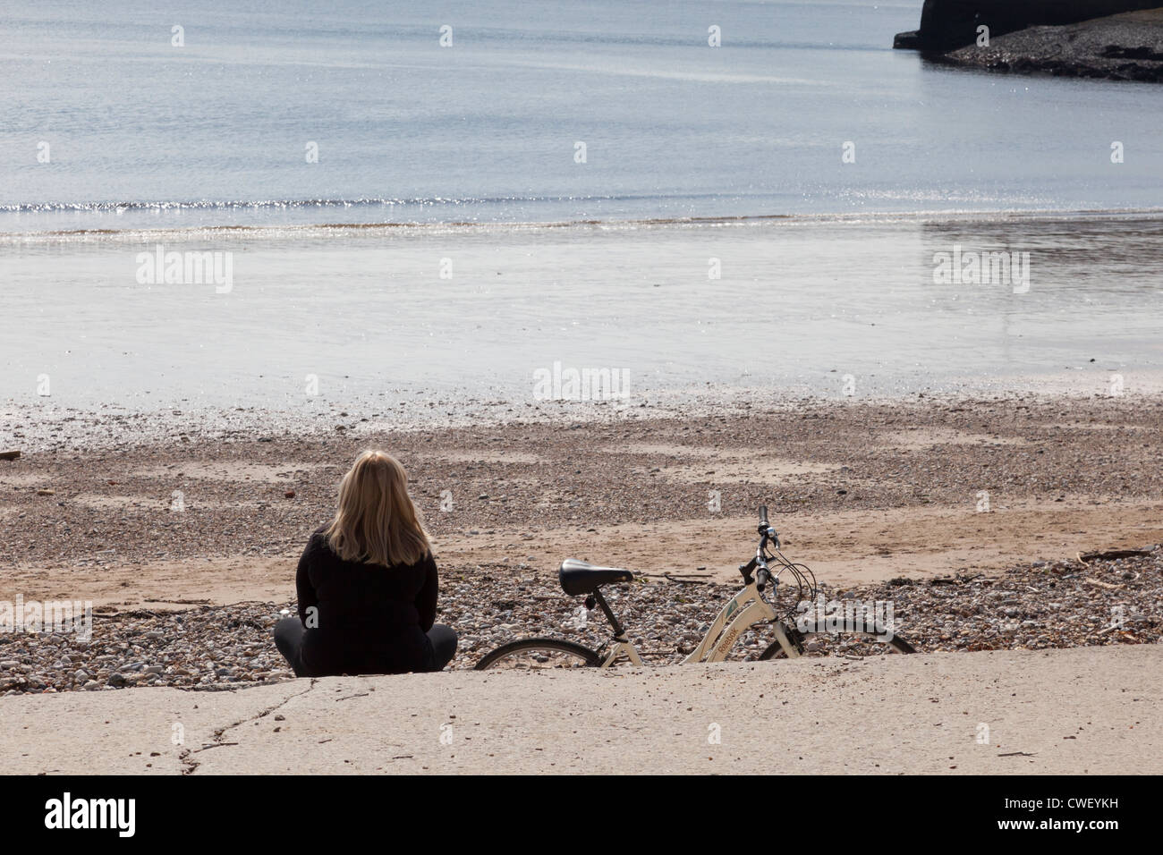Ein Radfahrer Frau ruht auf Roker Strandpromenade, Sunderland, Tyne und Abnutzung, England, UK Stockfoto