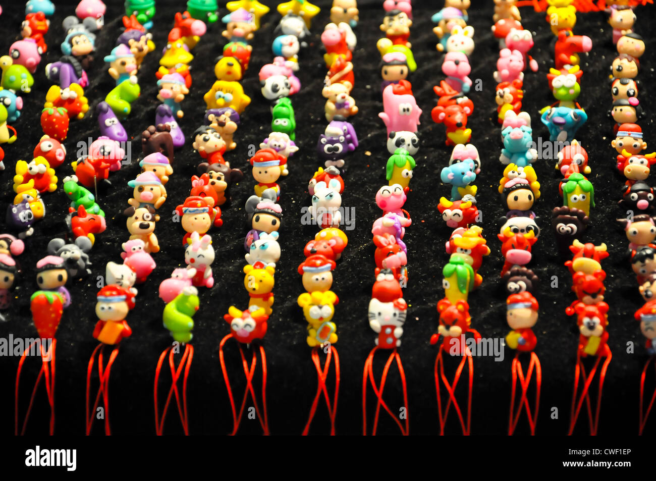 bunte chinesische Anhänger in Form verschiedener Tiere, Früchte und Spielzeug Stockfoto