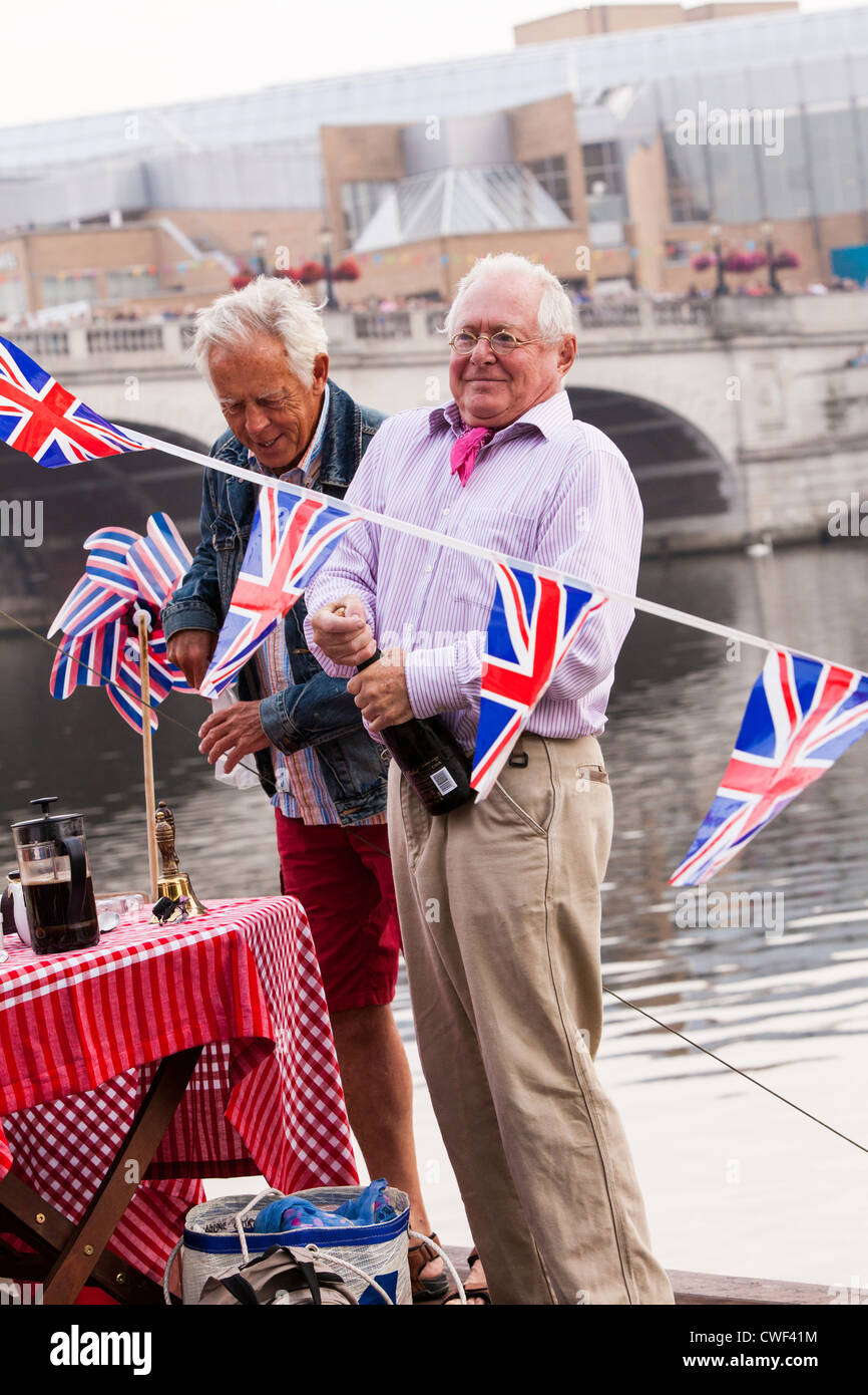 Tauchen den Korken auf eine Flasche Champagner festlichen just-in-Time für Royal Barge, Gloriana Kingston Bridge vorbei. Stockfoto