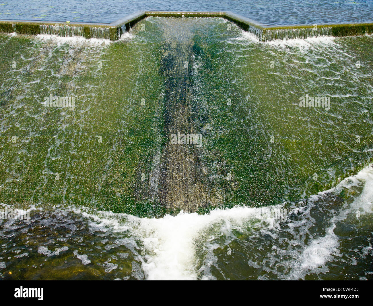 Wasser fließt über ein Wehr. Stockfoto