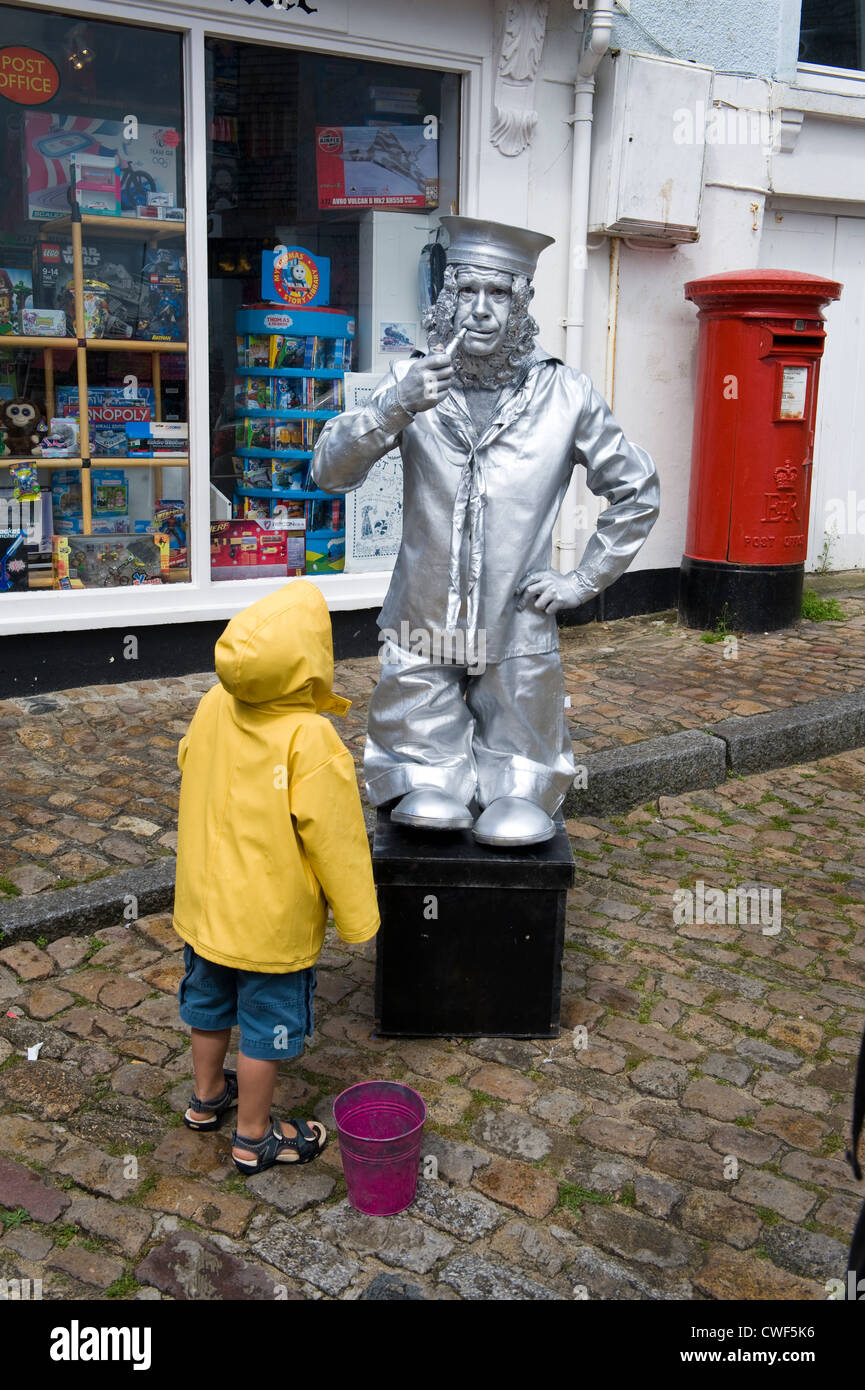 Silber lackierten Streetart-Künstler Seethema St Ives Cornwall beobachtet von einem Kind Stockfoto