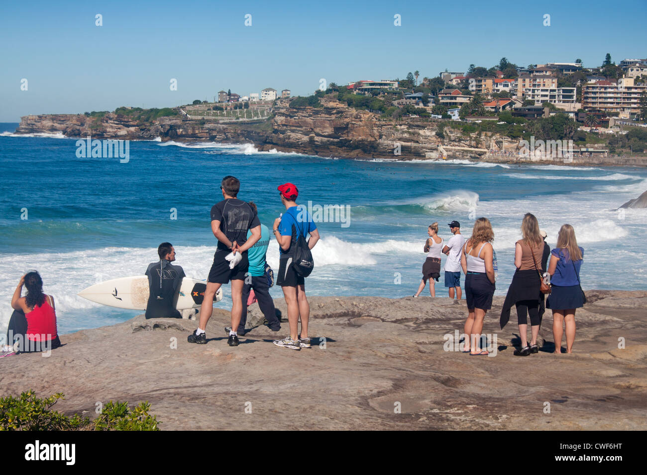 Menschen stehen und sitzen auf den Felsen über Tamarama Beach blickte Küste in Richtung Bronte Sydney New South Wales Australien Stockfoto