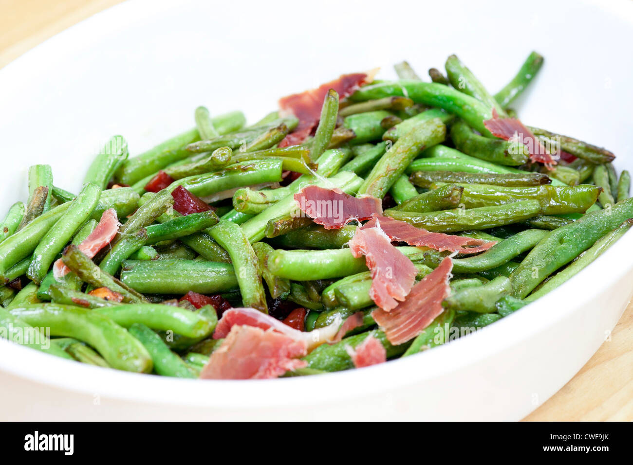 Salat - gebratene grüne Bohnen mit Serrano-Schinken Stockfoto