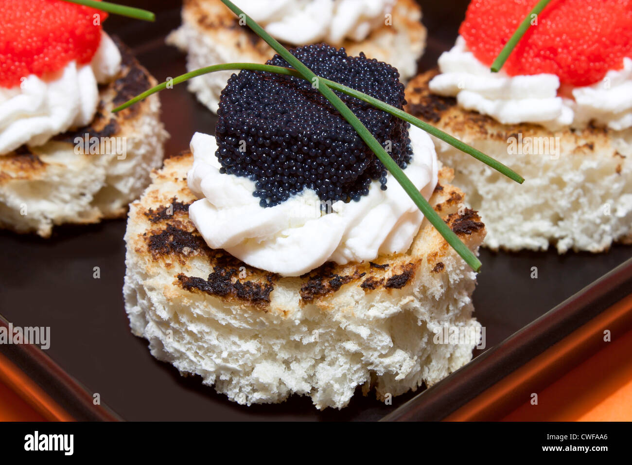 Roten und schwarzen Kaviar Kanapees dekoriert mit Schnittlauch ...