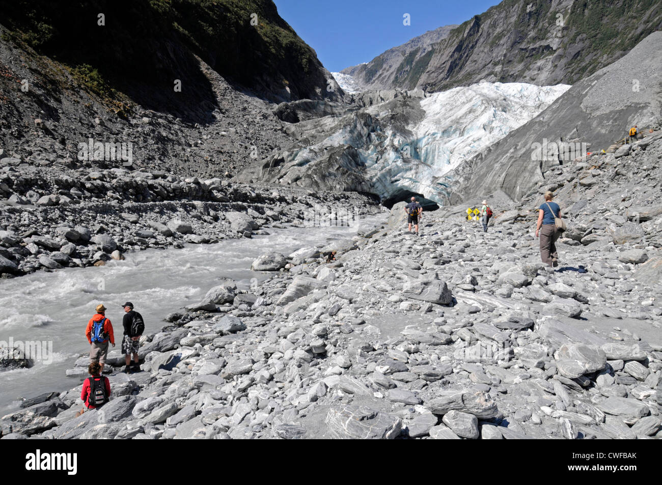 Besucher am Ufer eines schnell fließenden Flusses am Fuße des the12 km langen Franz-Josef-Gletschers im Westland-Tai-Poutini-Nationalpark im Westen Stockfoto