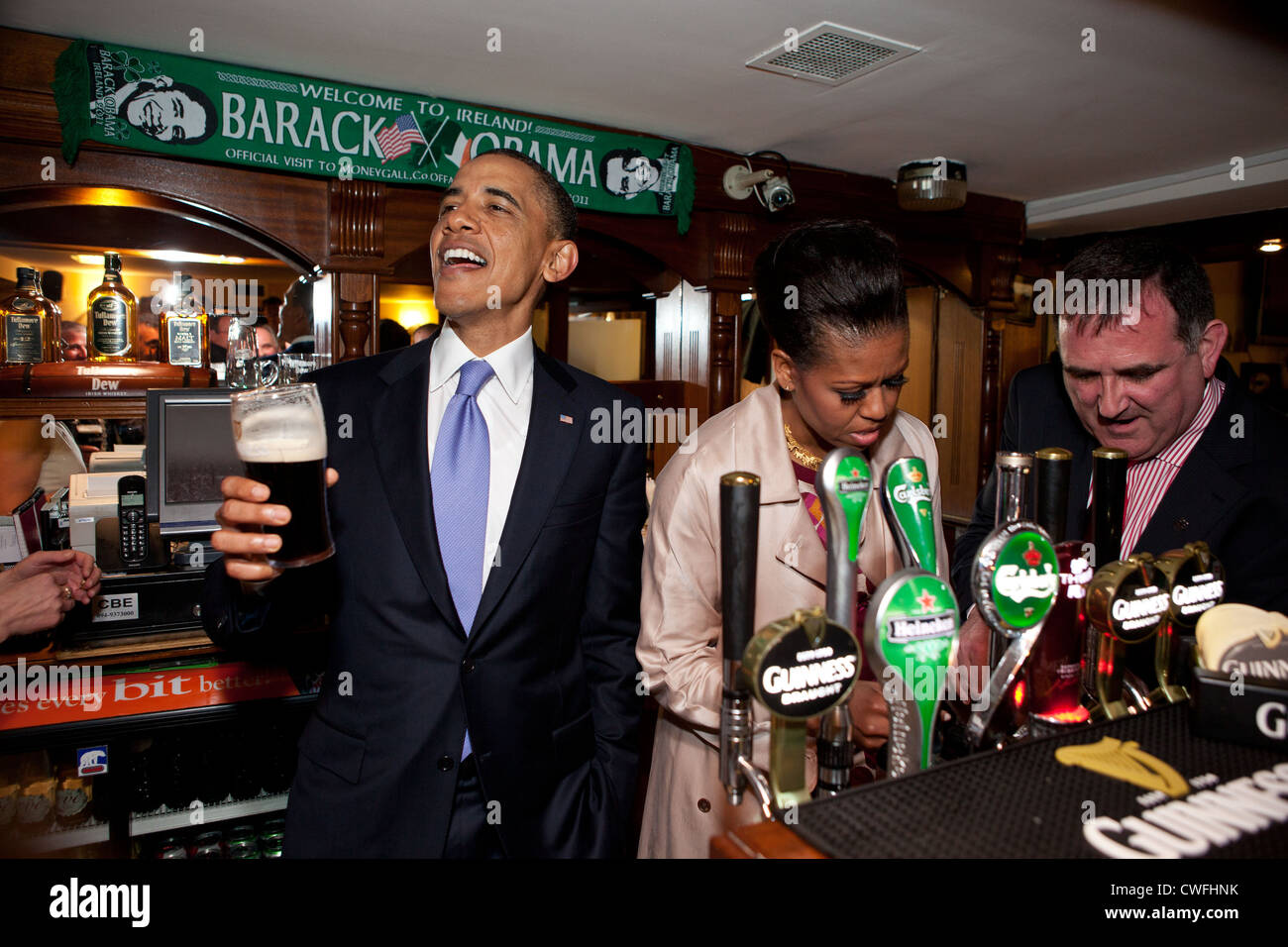 Präsident Barack Obama spricht mit Pub-Besucher als First Lady Michelle Obama einen Pint im Pub Ollie Hayes in Moneygall, Irland zieht, Stockfoto