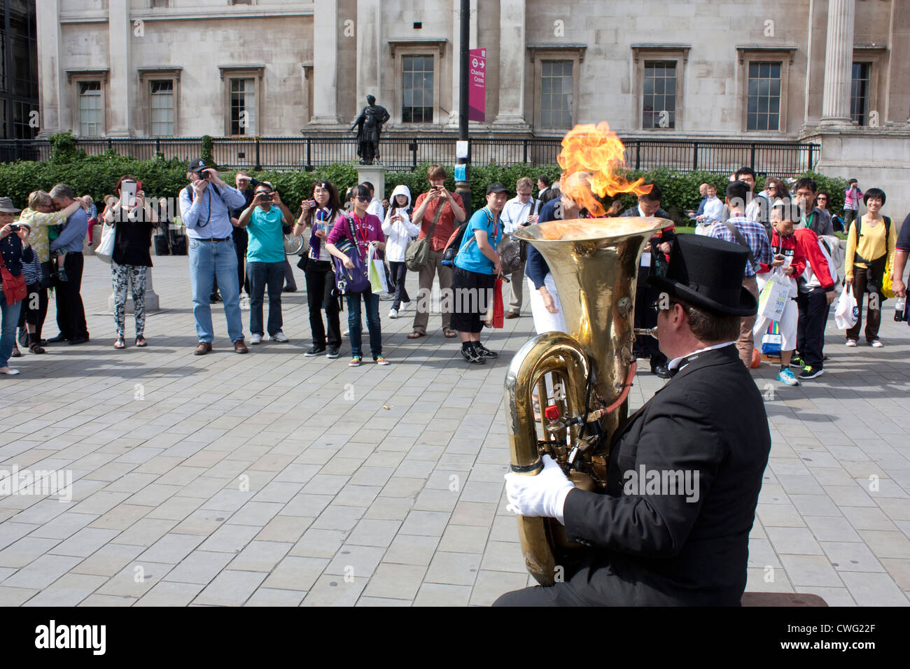 Eine Straße Entertainer weht Flammen aus einer Tuba am Trafalgar Square in London. Stockfoto