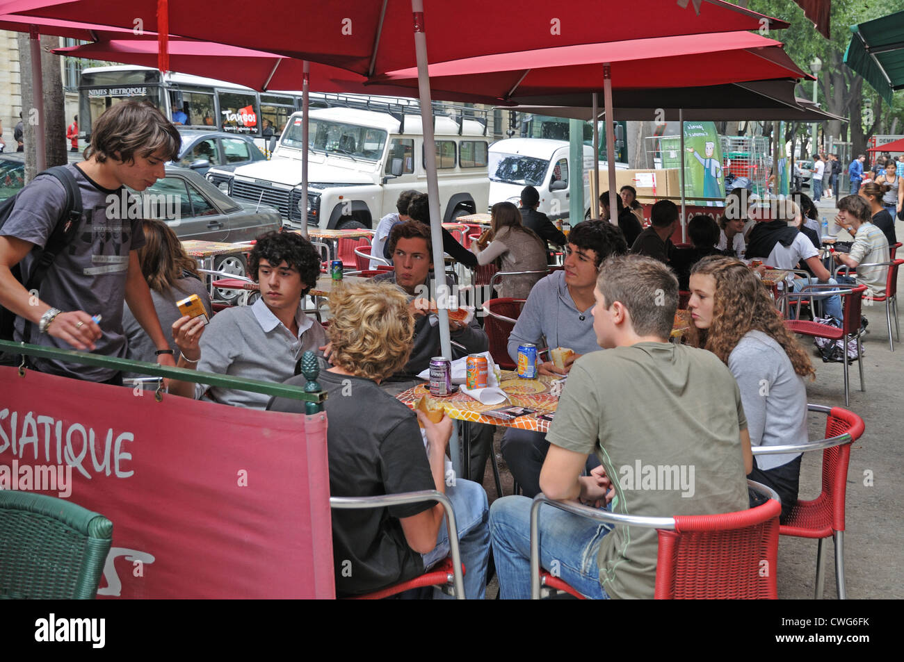 Junge Menschen genießen eine Pause im Straßencafé auf Victor Hugo Boulevard Nimes France Stockfoto