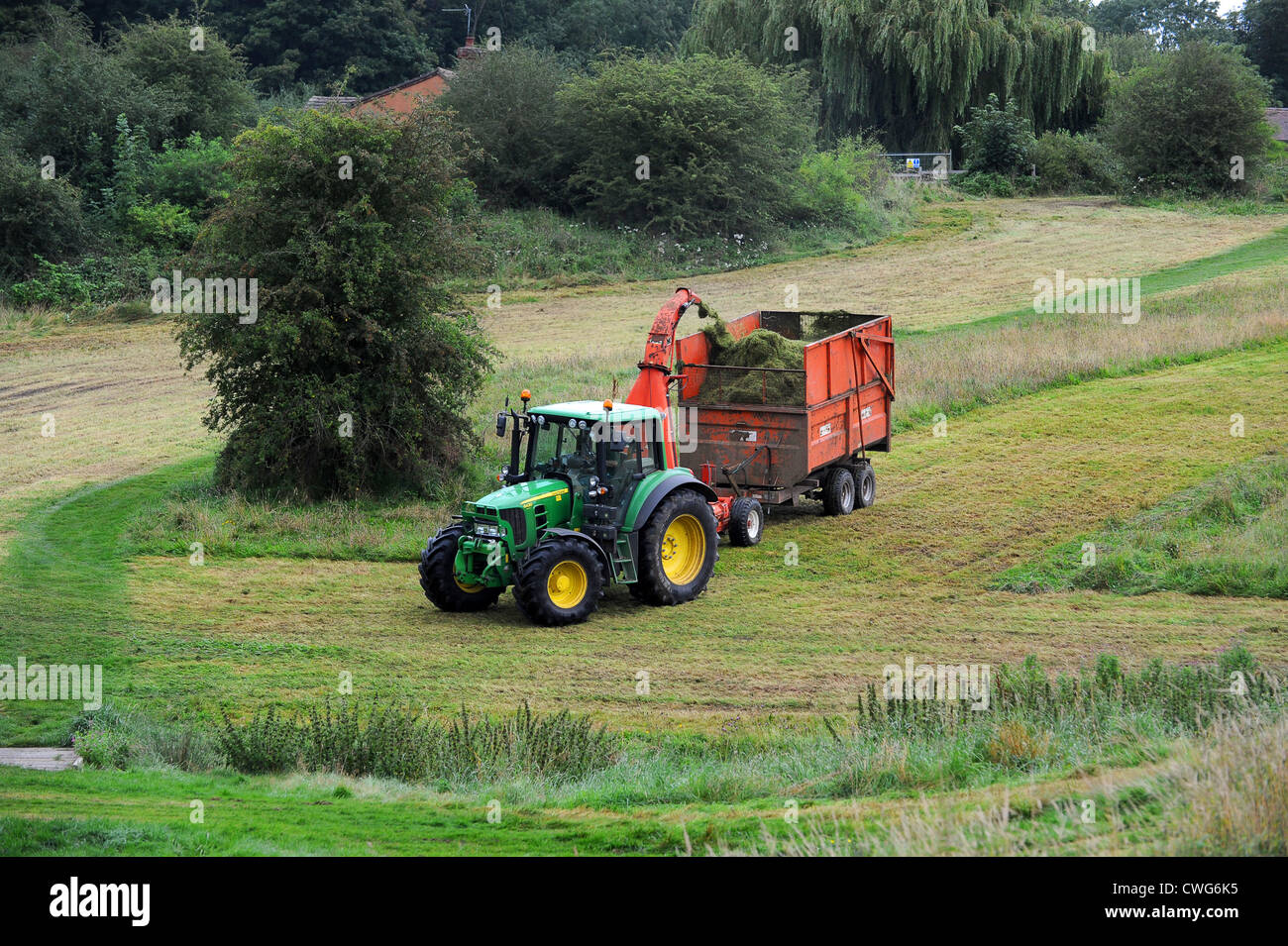 Traktor Ausschnittgras auf Wiese in Shropshire, England Uk Stockfoto