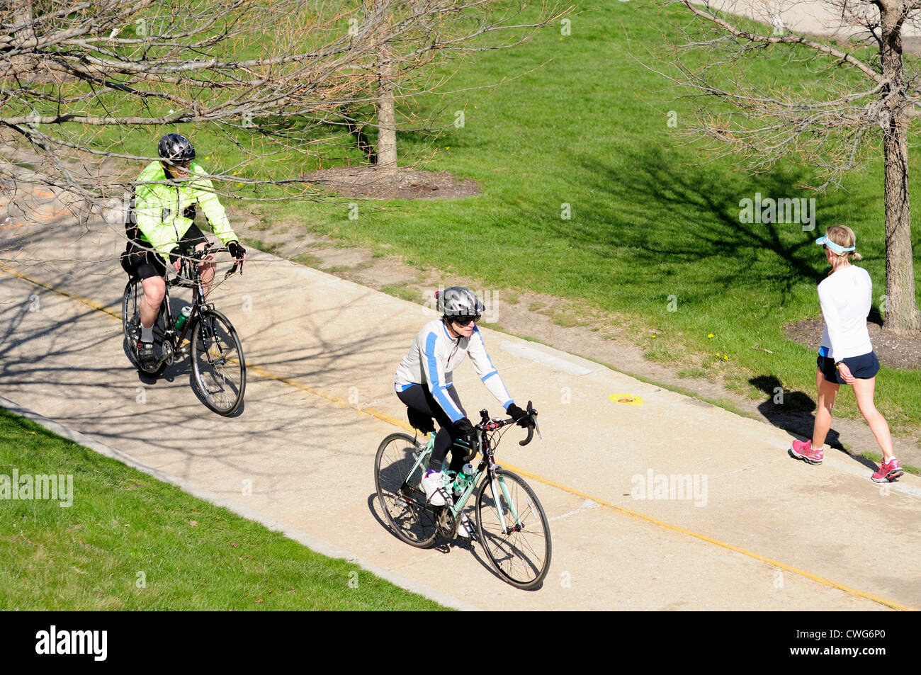 Übung-Radfahrer und ein einsamer Wanderer nutzen einen Radweg im Grant Park in einem Frühlingsmorgen. USA-Illinois-Chicago Stockfoto