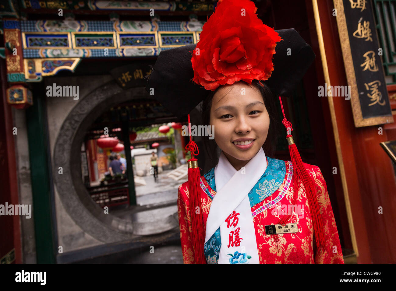 Eine junge Frau, gekleidet in traditionellen chinesischen Tracht im Fangshan Imperial Restaurant begrüßen Kunden im Beihai-Park Bei Stockfoto