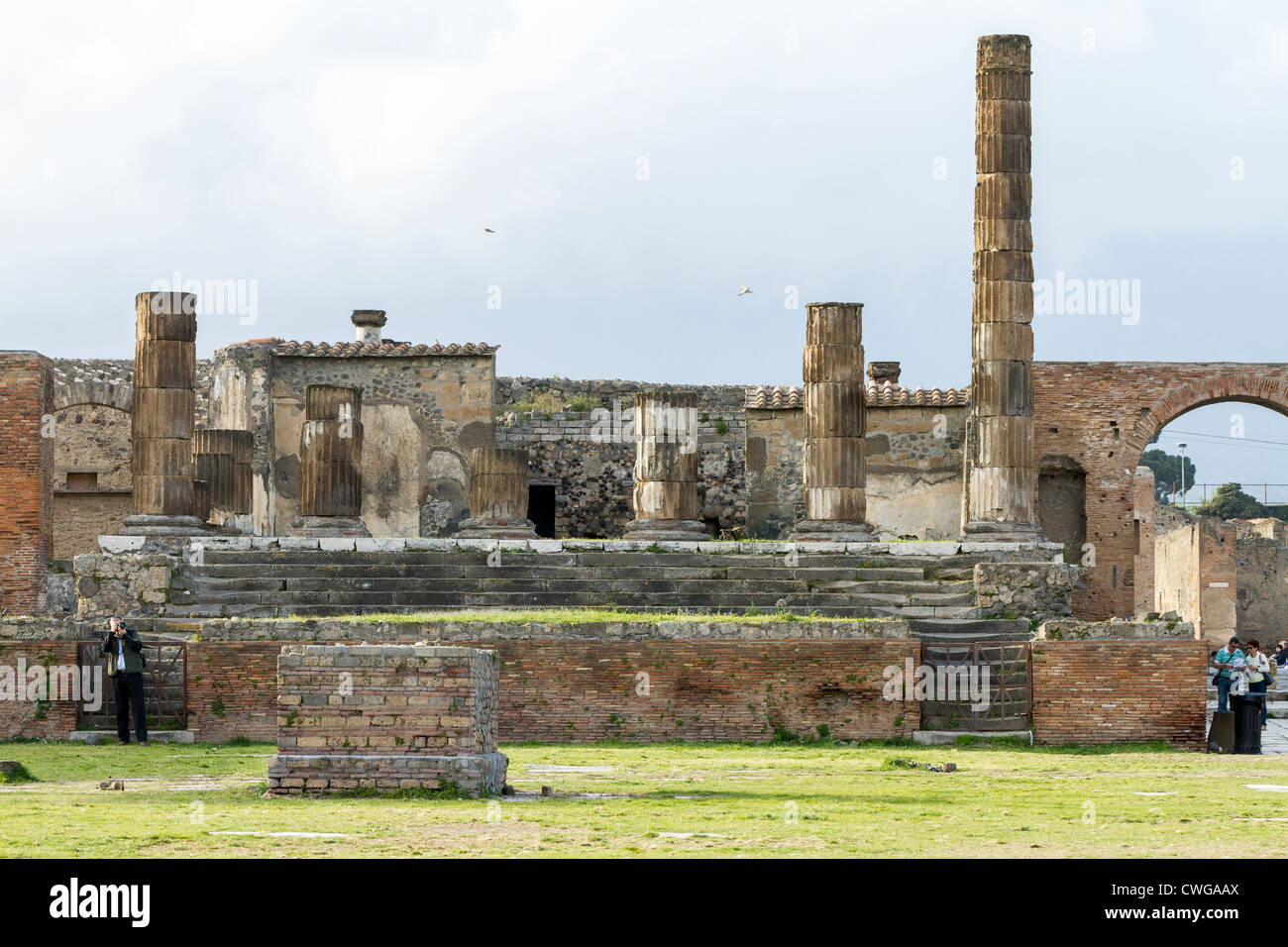 Das Forum auf die antike römische Stadt Pompeji, ein Tourist nimmt ein Foto und zwei andere suchen in einem Reiseführer oder Karte Stockfoto