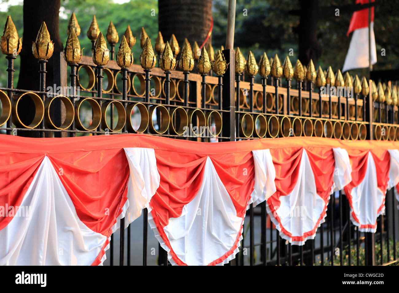 Indonesische Fahnen drapiert über einen gusseisernen Zaun für Indonesien Independence Day feiern in Jakarta. Stockfoto