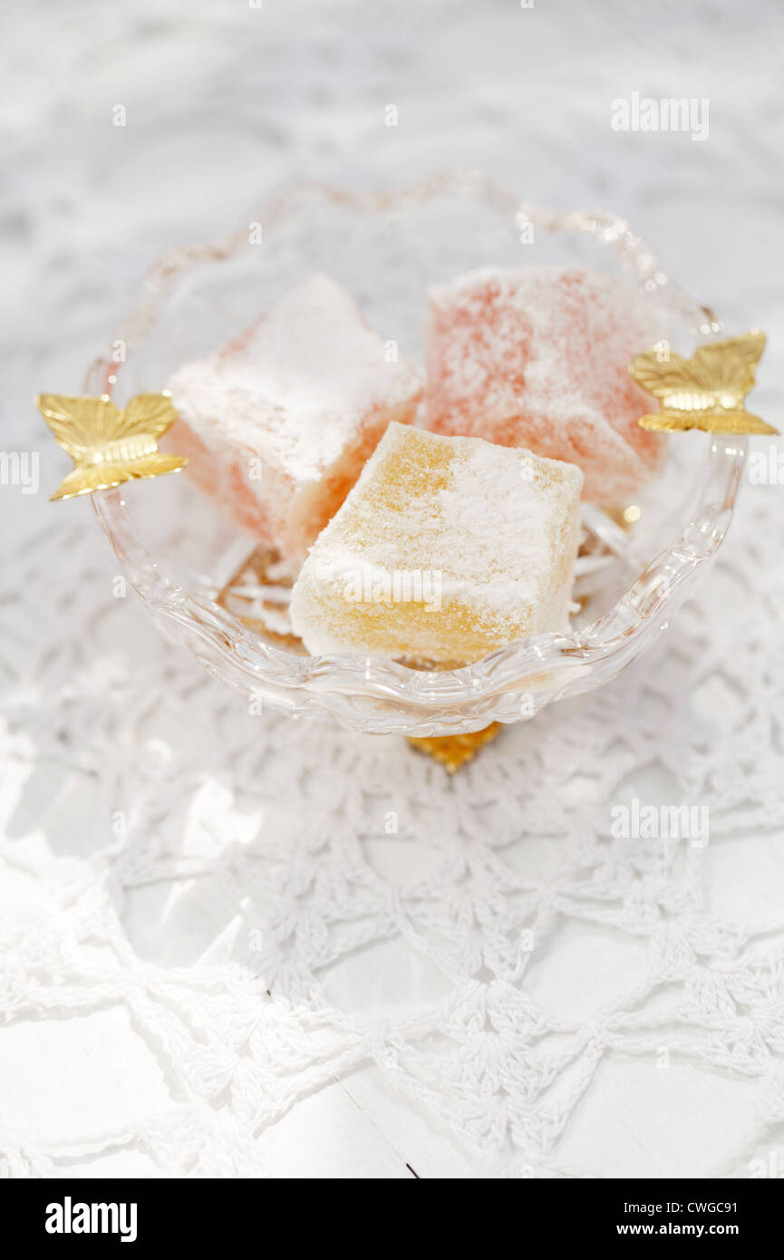 türkische süße Freude, rosa und gelb, im kleinen Glas Schüssel Schmetterling verziert Stockfoto