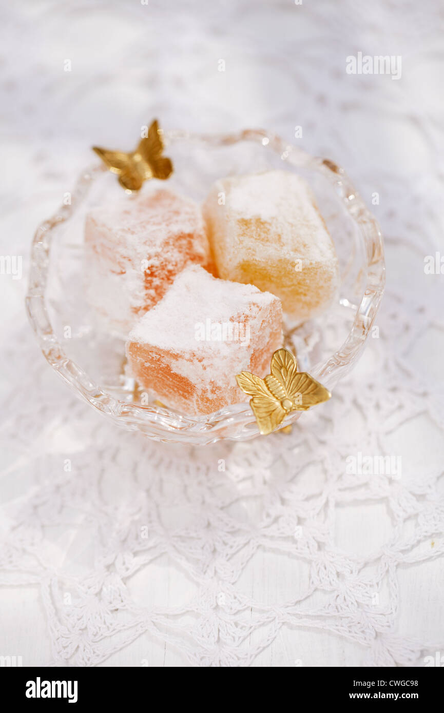 türkische süße Freude, rosa und gelb, im kleinen Glas Schüssel Schmetterling verziert Stockfoto