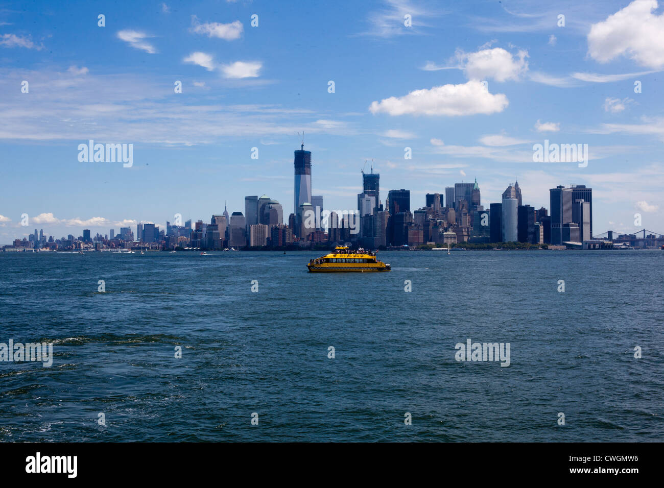 Ein Touristenboot ist im Hafen von New York mit Manhattan Insel im Hintergrund gesehen. Stockfoto