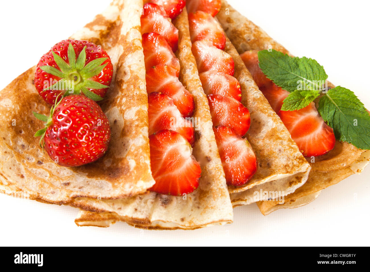 Dünne Pfannkuchen mit Erdbeeren und Minze gerollt Stockfoto