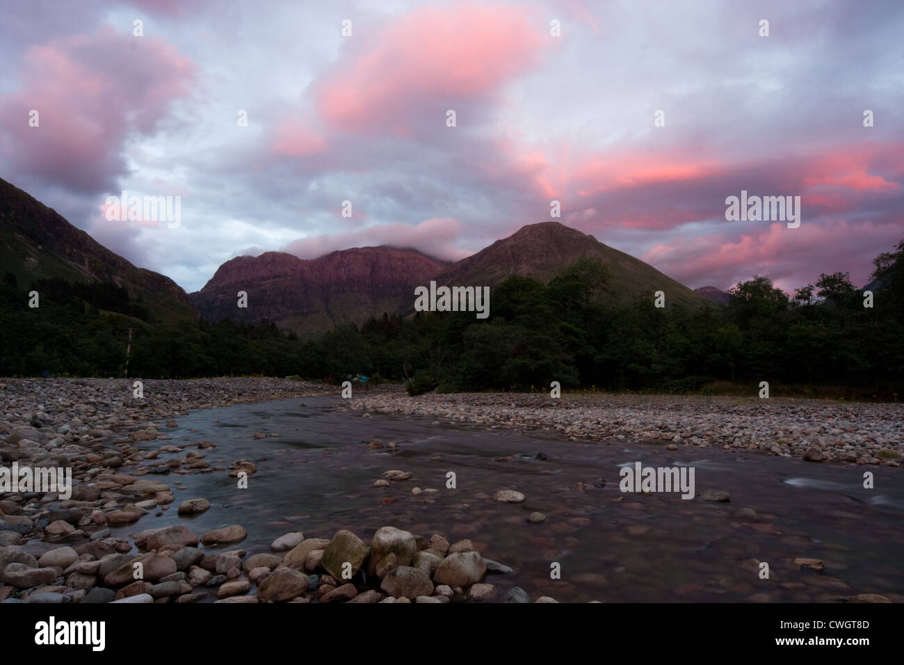 Fluss bei Sonnenuntergang, dunkle Landschaft mit roten Wolken Stockfoto