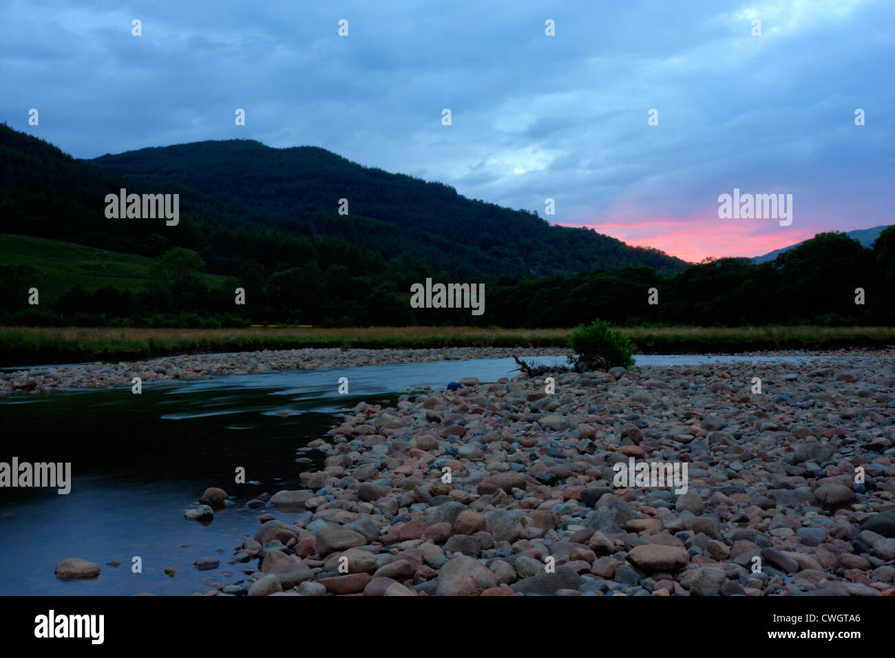 Fluss bei Sonnenuntergang, dunkle Landschaft mit roten Wolken Stockfoto