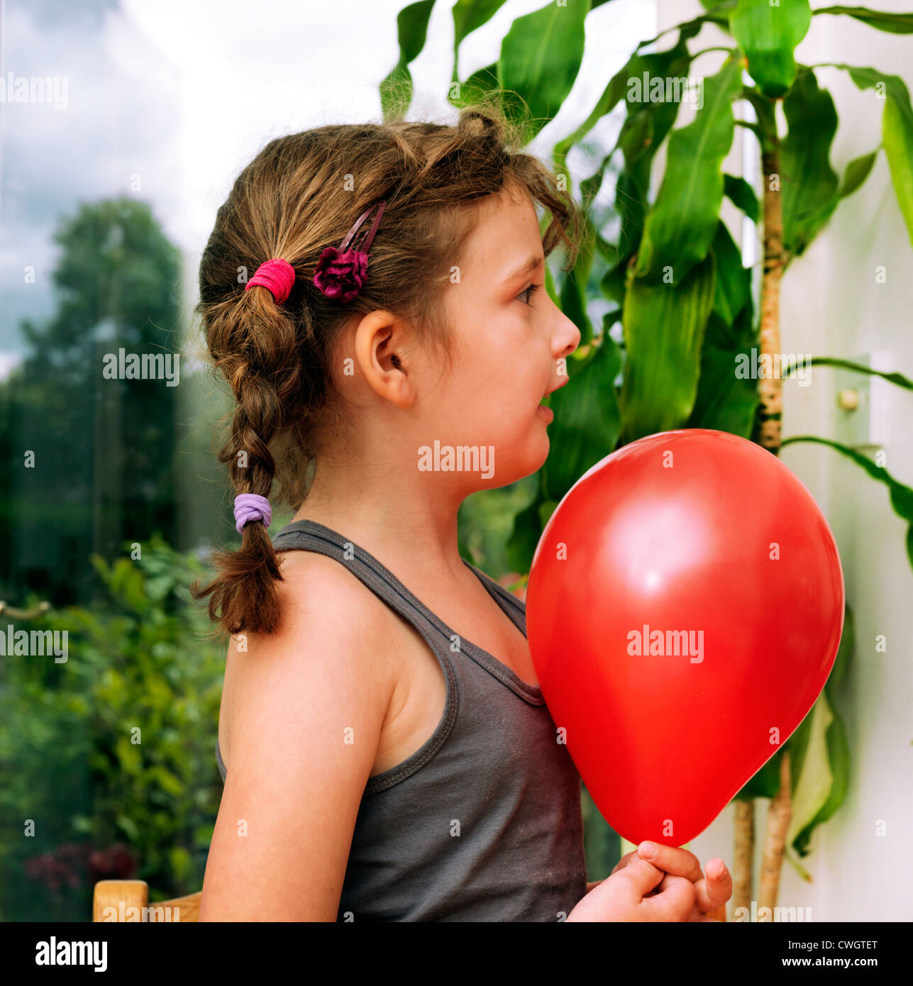 Mädchen, die statische Elektrizität, indem Sie reiben Ballon auf Weste Top England Stockfoto