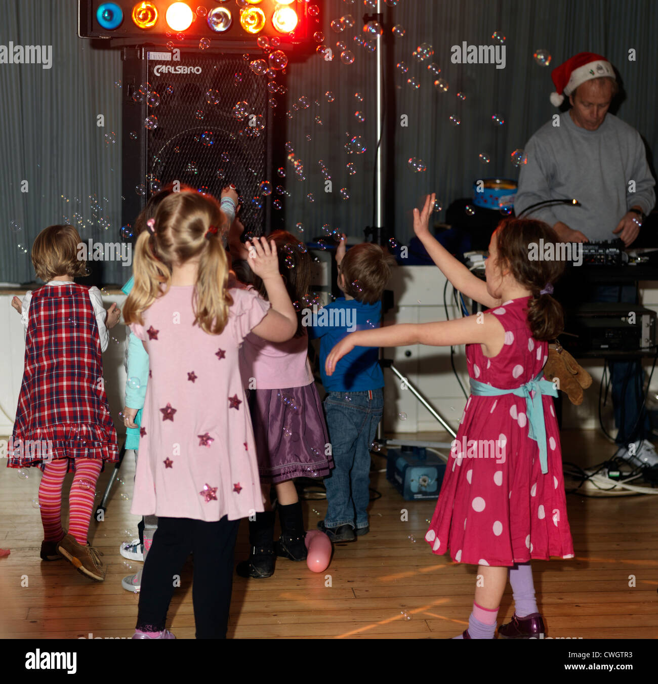 Kinder tanzen mit Luftblasen in einer Diskothek in einer fünften Geburtstag feiern England Stockfoto
