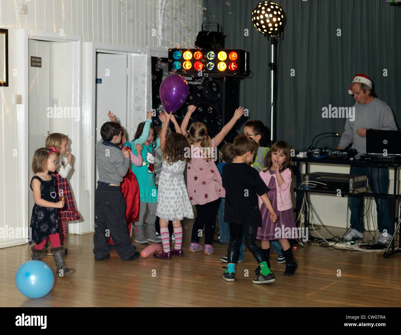Kinder tanzen mit Luftblasen in einer Diskothek in einer fünften Geburtstag feiern England Stockfoto