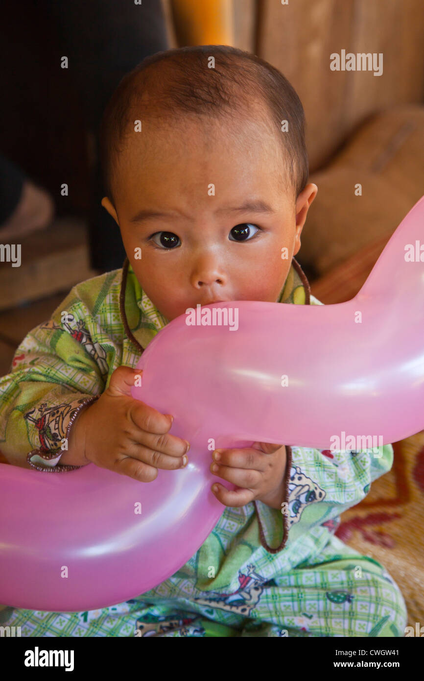 Ein junges Mädchen genießt ihr Ballon in einem SHAN-Dorf in der Nähe von KENGTUNG auch bekannt als KYAINGTONG - MYANMAR Stockfoto