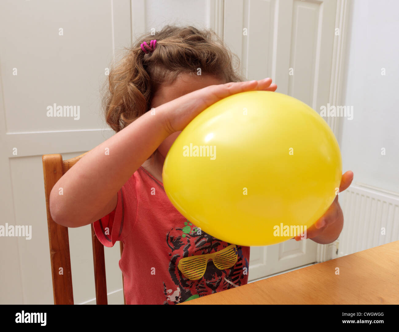 Junges Mädchen mit gelben Ballon stecken, nach reiben um statische Strom England zu erstellen Stockfoto