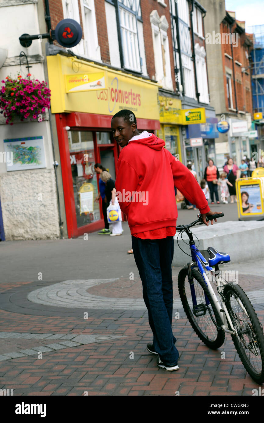Afro Karibik Mann zu Fuß mit dem Fahrrad auf der Straße Sutton Surrey England Stockfoto