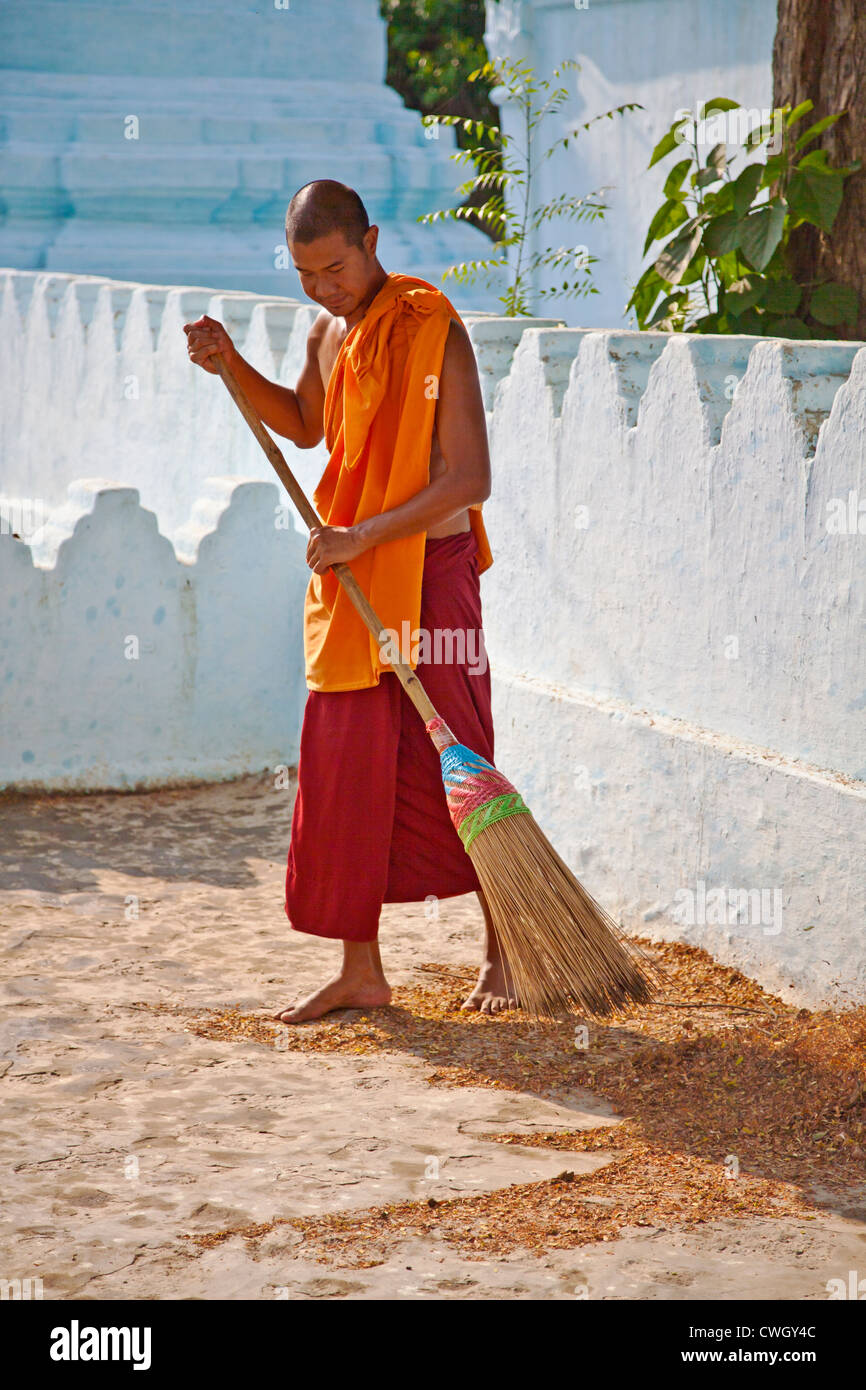 Ein Mönch reinigt das Gelände der TAUNG MIN GYI Pagode in AMARAPURA der alten königlichen Hauptstadt 11 Kilometer von MANDALAY - MYANMAR Stockfoto