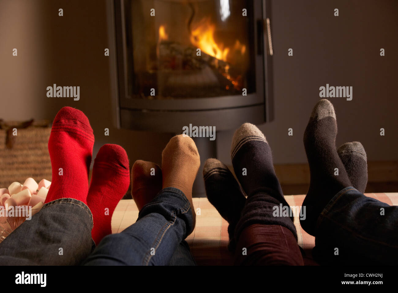 Nahaufnahme eines Familys Füße entspannenden gemütlichen Kaminfeuer mit Marshmallows Stockfoto
