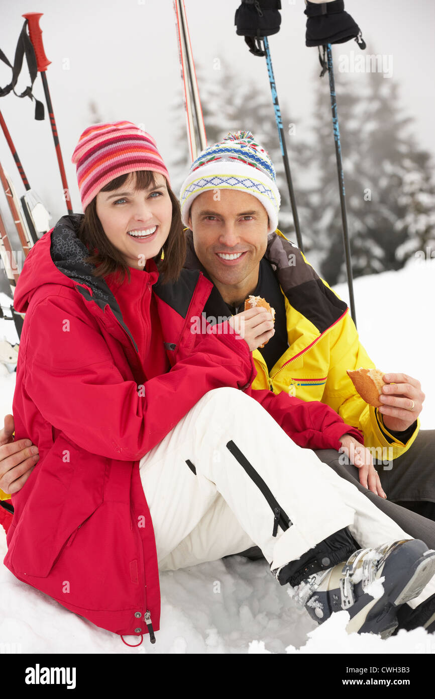Applying paar Essen Sandwich auf Skiurlaub In Bergen Stockfoto