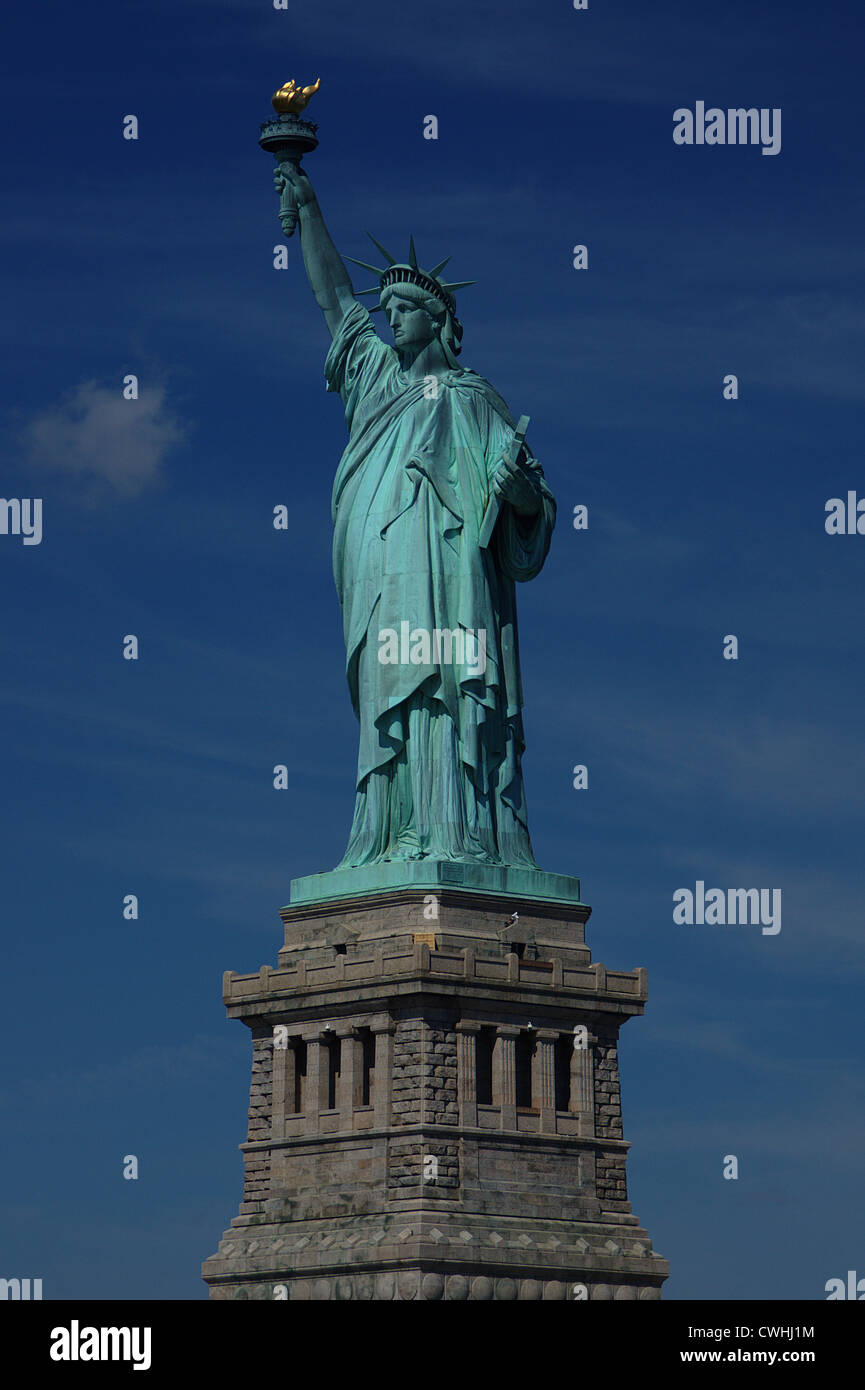 Die Freiheitsstatue im Hafen von New York auf Sockel mit Fackel gegen ein strahlend blauer Himmel empor gehalten. Stockfoto