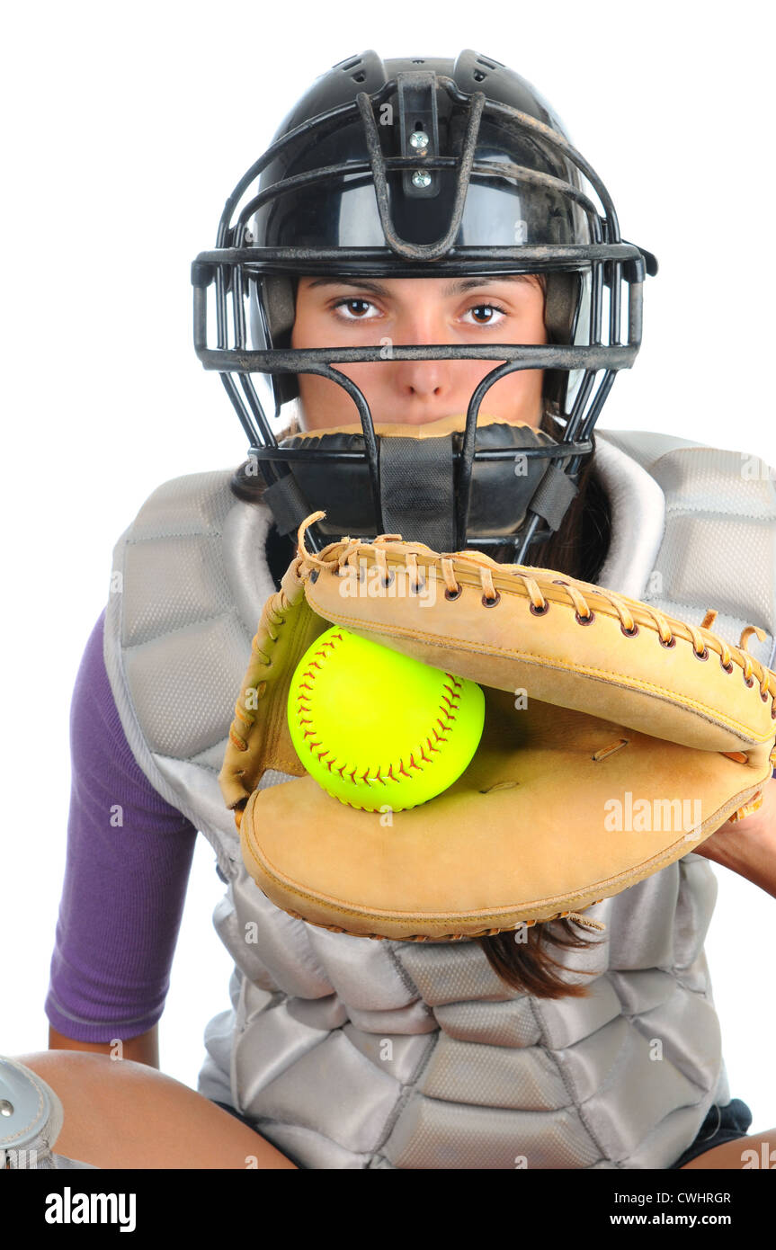 Nahaufnahme von einem weiblichen Softball Catcher trägt eine Maske und Brust Protektor Handschuh mit Ball im Web vor ihr halten. Stockfoto