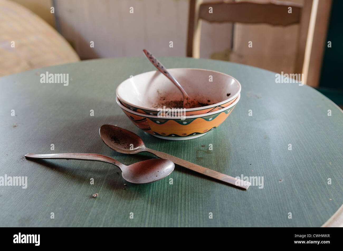 Schmutzige Schüsseln und Löffel auf einem Küchentisch, die eine lange Zeit geblieben sind Stockfoto