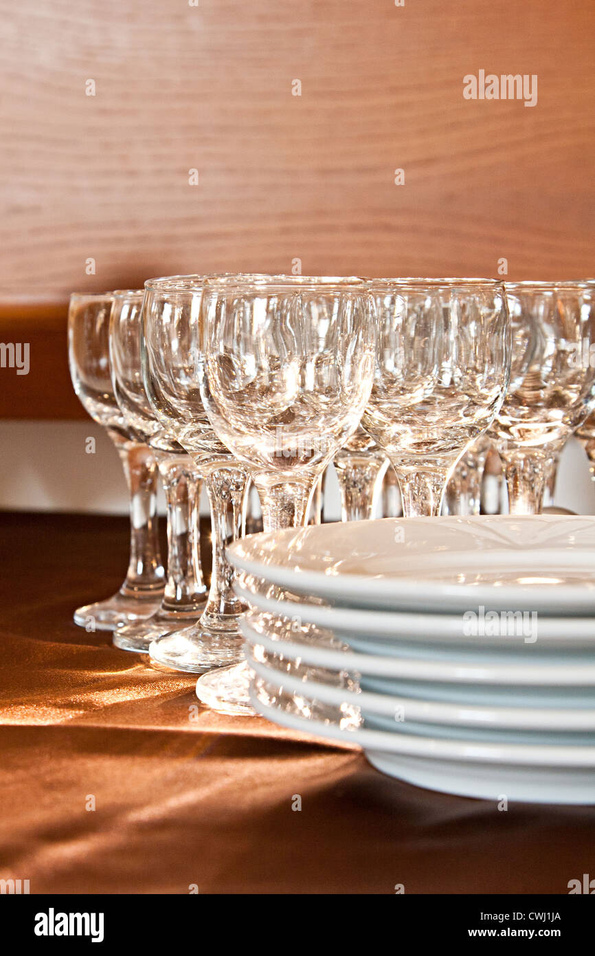 Glas und Teller auf braun Tischdecke Stockfoto