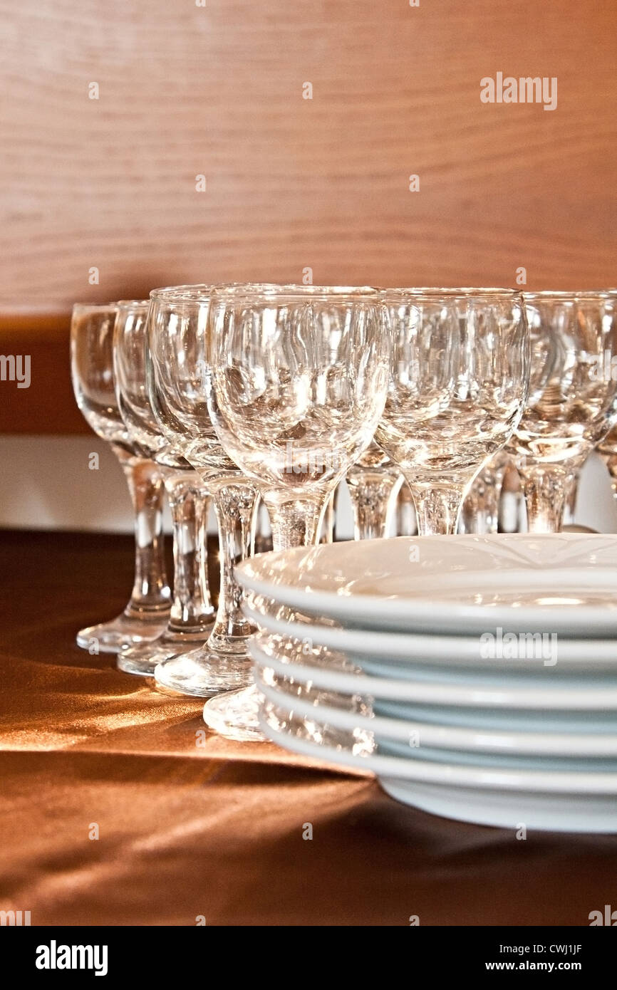 Glas und Teller auf braun Tischdecke Stockfoto