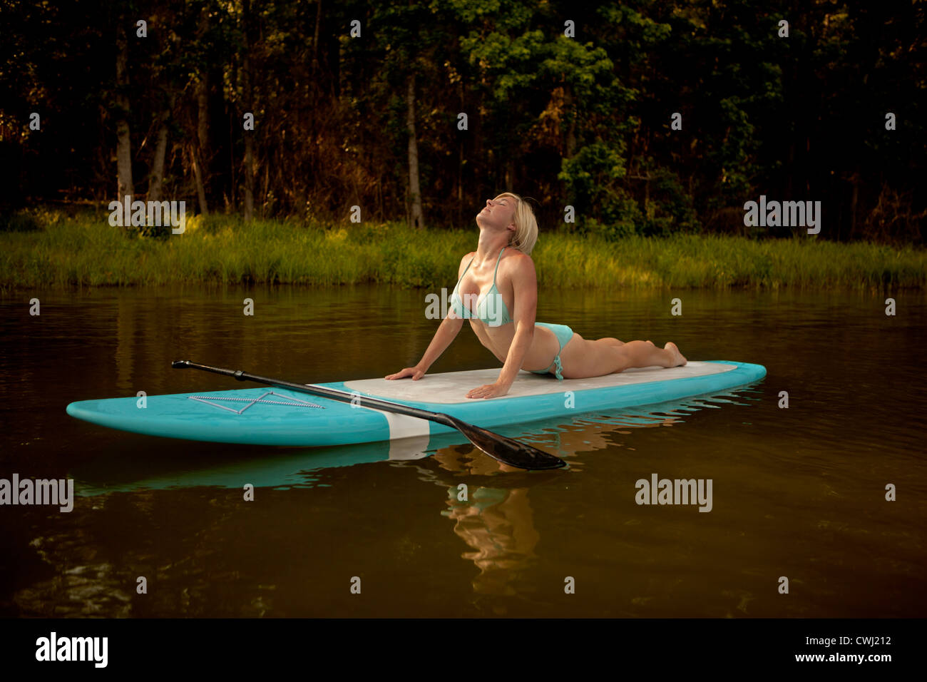 Kaukasische Frau praktizieren Yoga auf paddleboard Stockfoto