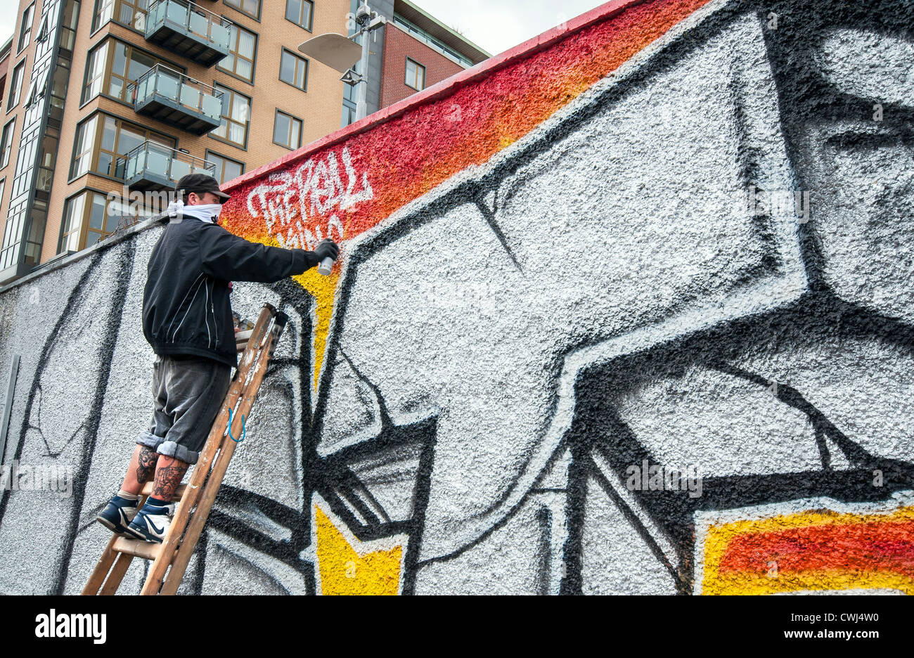 Graffiti-Künstler, die den letzten Schliff zu seiner Wandarbeit Stockfoto