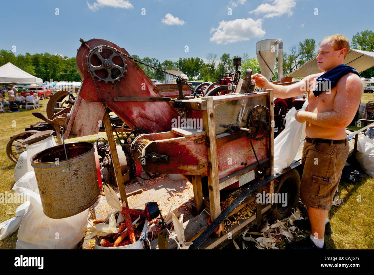 Man Betrieb Mais schälen Maschine bei einem antiken Gas und Dampf-Motor Show in Fort Hunter, Erie-Kanal Upstate New York Stockfoto