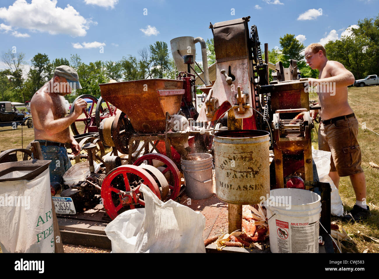 Männer, die Mais schälen Maschine an einem antiken Gas und Dampfmaschine in Betrieb zeigen bei Fort Hunter, Erie-Kanal Upstate New York Stockfoto