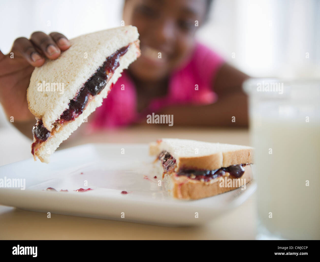 Schwarzes Mädchen essen, Erdnussbutter und Marmelade-sandwich Stockfoto