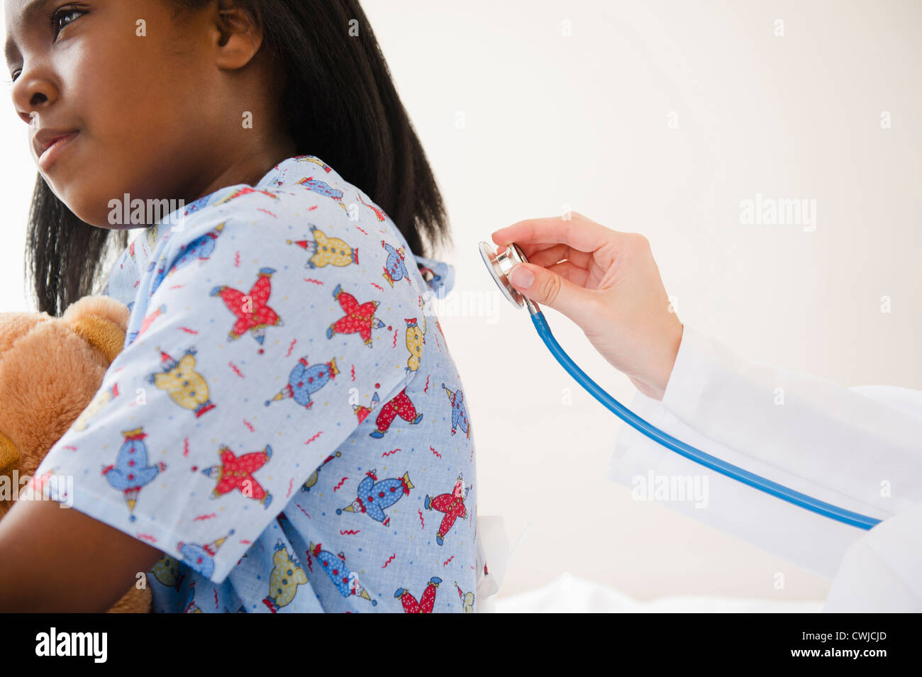 Arzt mit Stethoskop auf schwarzes Mädchen im Krankenhaus Stockfoto