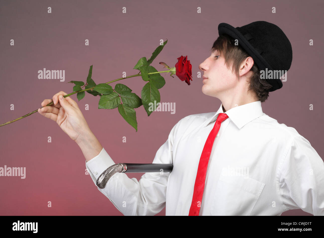 Junge Männer mit der roten Rose auf Farbe Hintergrund. Liebe und Reflexion. Stockfoto