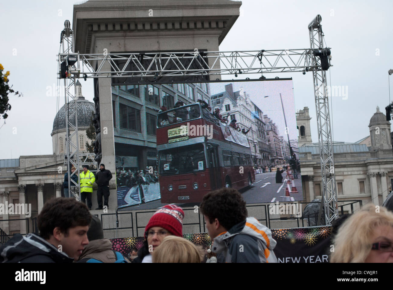 Offenen gekrönt Bus auf großen Bildschirm an der Basis der Nelsonsäule in Trafalgar Square zeigt die New Years Day parade Stockfoto