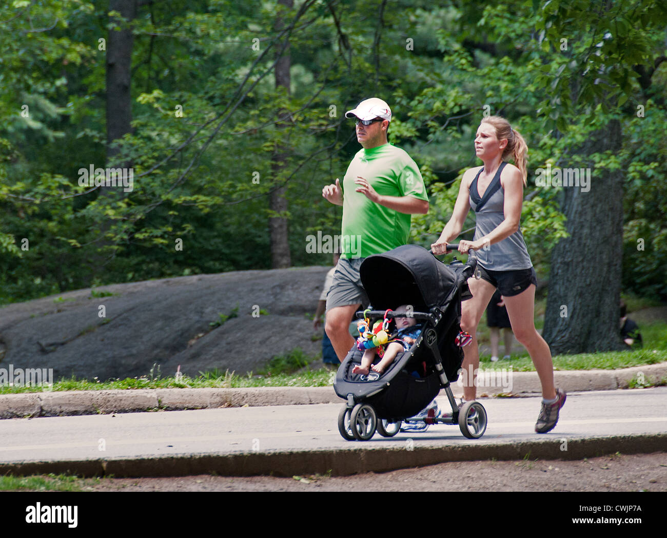 Läufer im Central Park in Manhattan in New York Frau mit Kinderwagen mit Kind sitzt Stockfoto