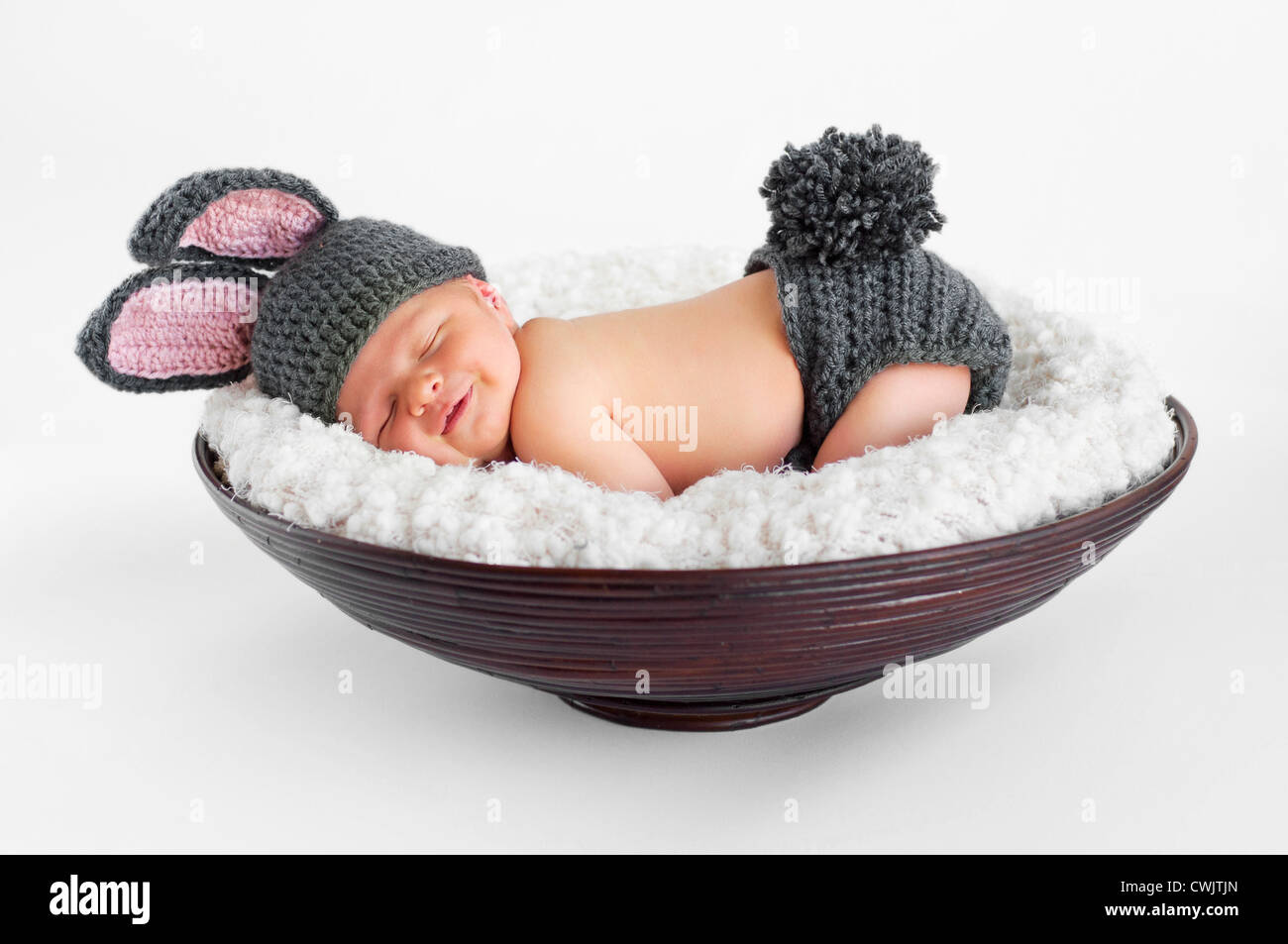 8 Tage alten lächelnden neugeborenes Baby junge in einem Kostüm Hasenohren  und Hase Schwanz - in einem Korb schlafen Stockfotografie - Alamy