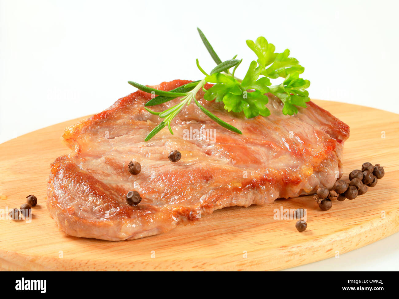 Schweinesteak auf Schneidebrett Stockfoto