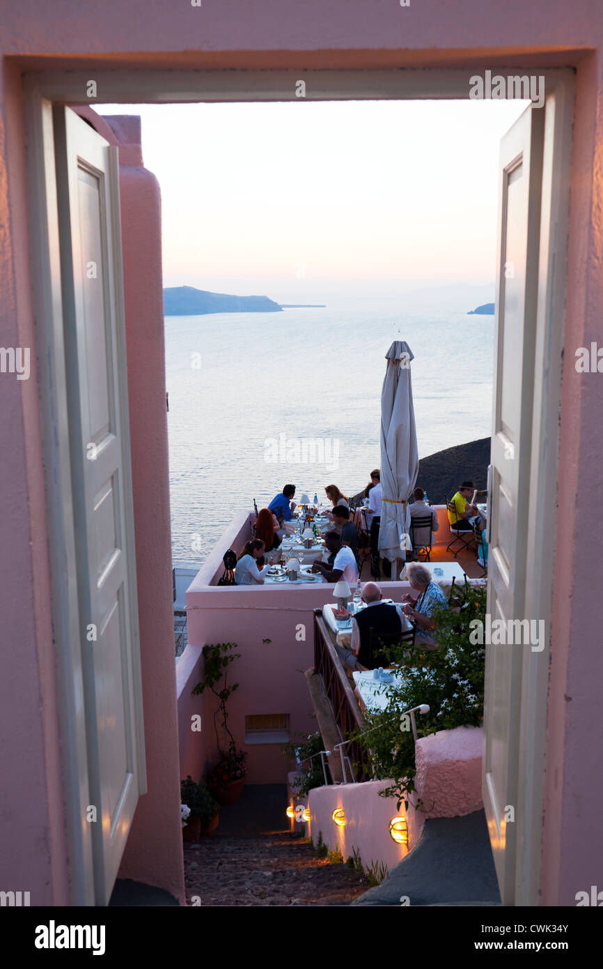 Santorini, griechische Insel, Kykladen, Griechenland, Eingang zum typischen Restaurant in Thira bei Dämmerung Menschen essen Stockfoto